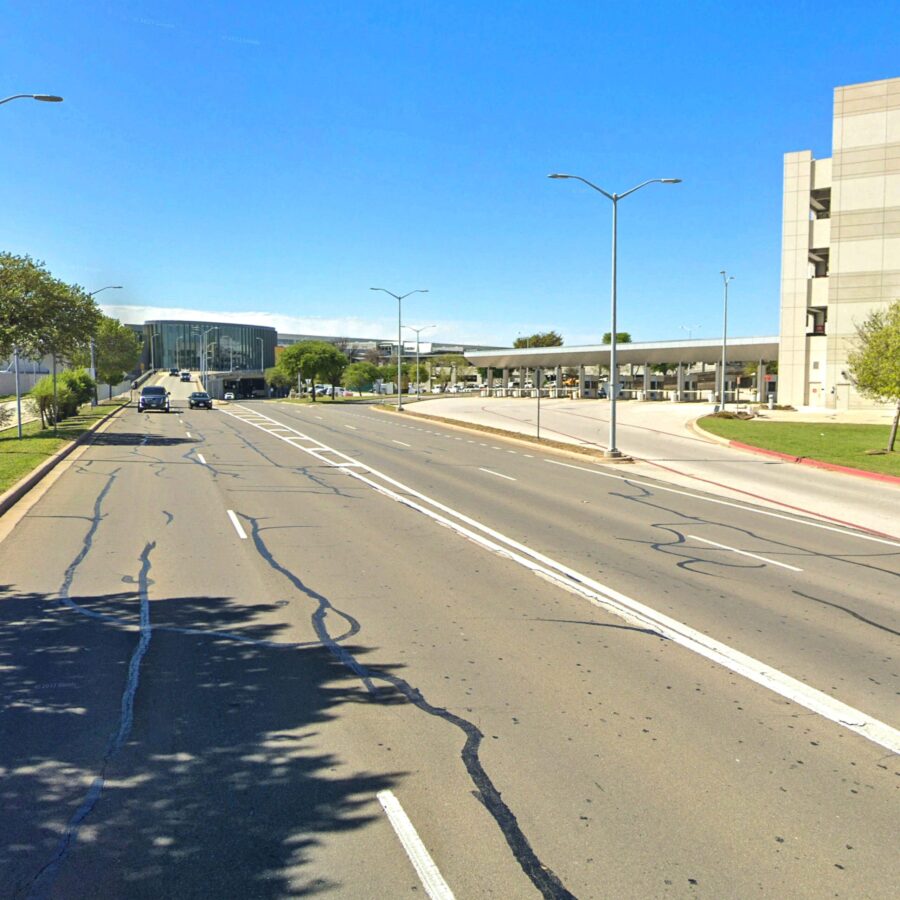street view of car driving away from airport