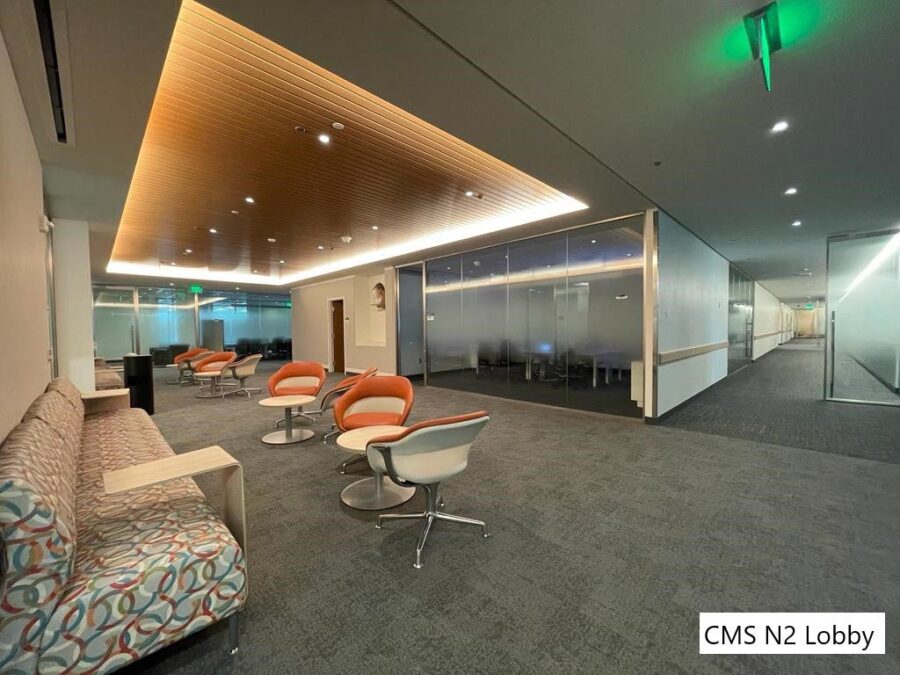 An indoor waiting room filled with chairs and a long couches.