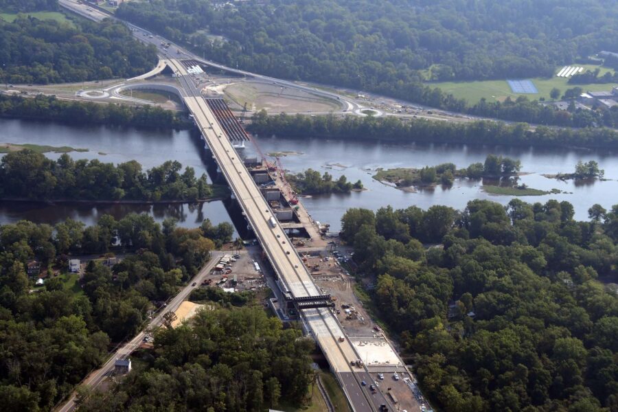 The Arial shot of a bridge, under construction, spanning across a river.
