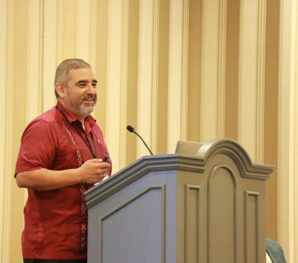 Man smiling and standing at a podium 