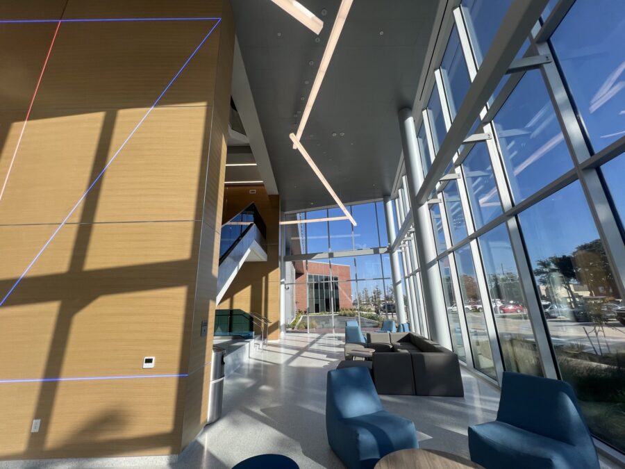 a large glass wall with a couch and chairs