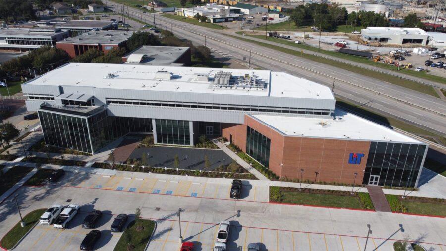 a building with a parking lot and cars parked in front