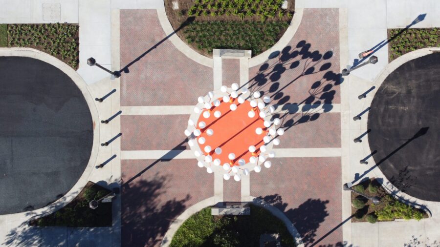 a circular orange light fixture and pedestrian space at a college