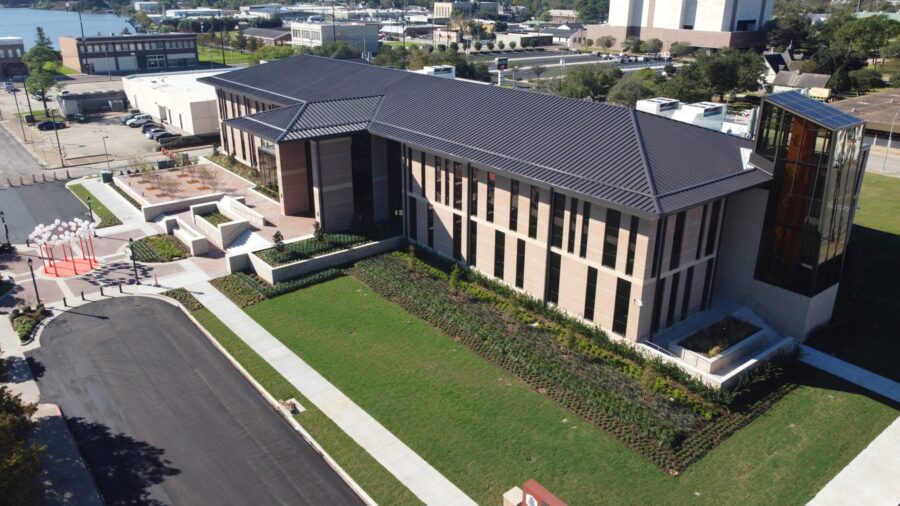 a college building with a lawn and a road