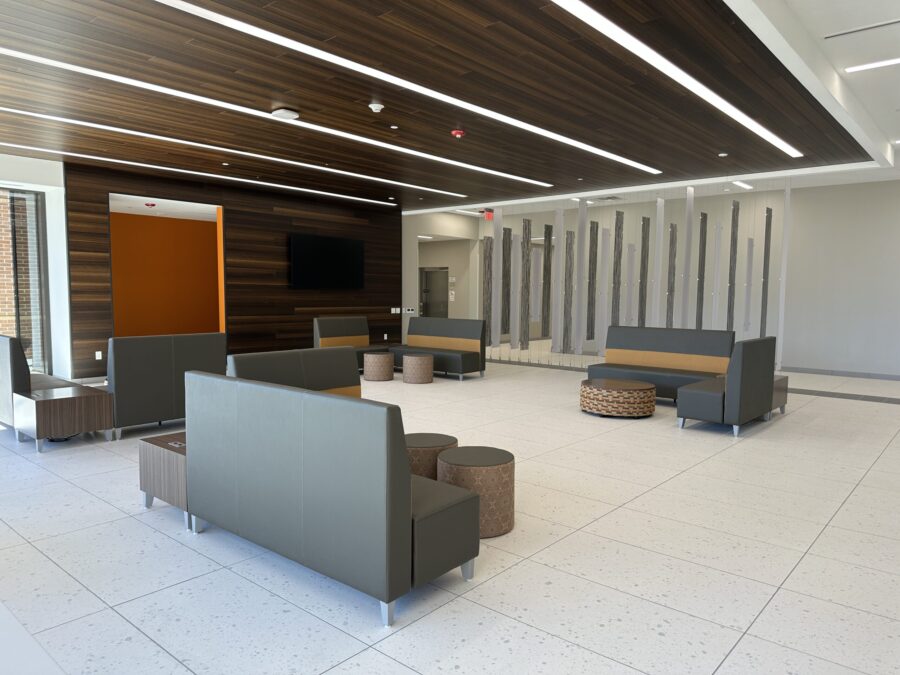 A common area filled with several arrangements of short couches and small tables