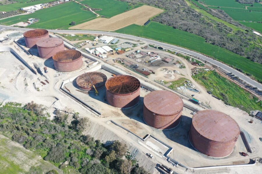 An aerial shot of seven large metal silos surrounded by dirt roads.