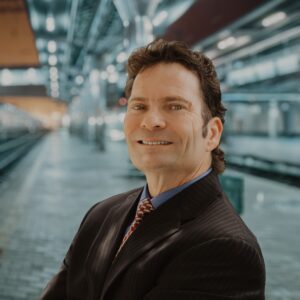 Man in a suit with blurred metro in the background