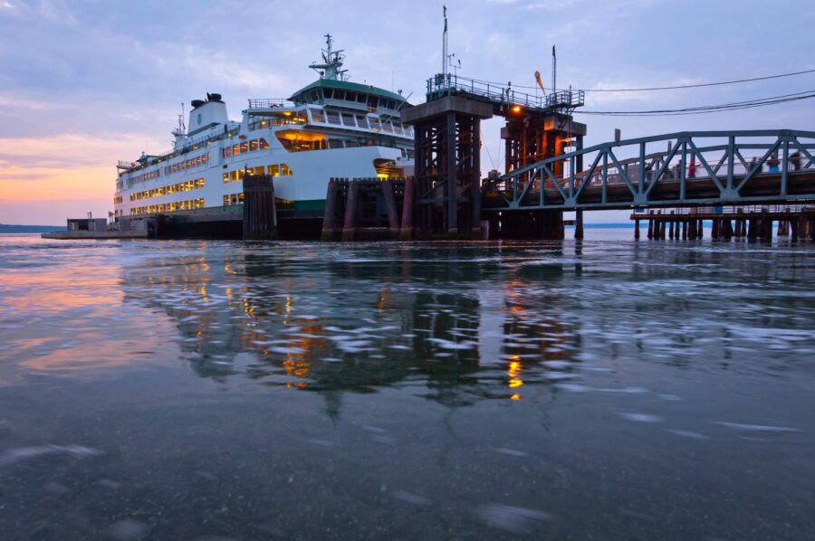 A large Ferry docked to a passenger bridge.