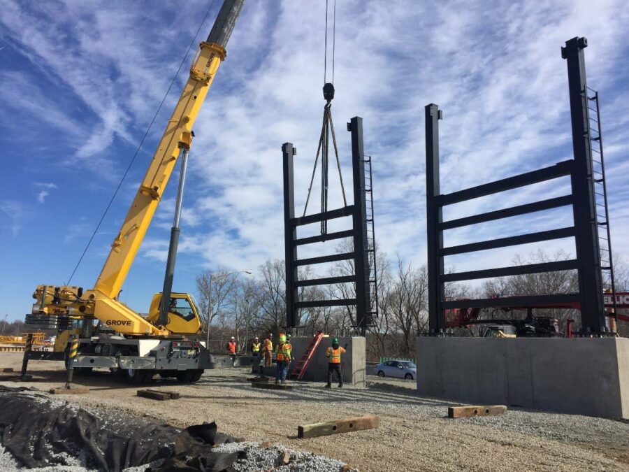 A carne lifting a large steel support structure.