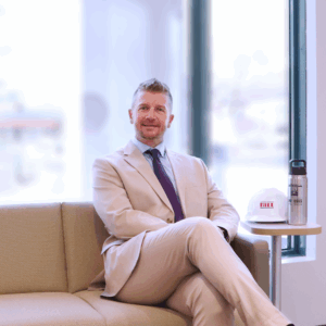 Man in a suit sitting on a couch in an office